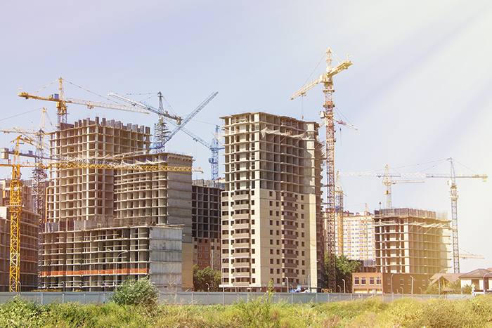 Construction site background. Hoisting cranes and new multi-storey buildings. tower crane and unfinished high-rise building. many cranes. construction of a new district of the city